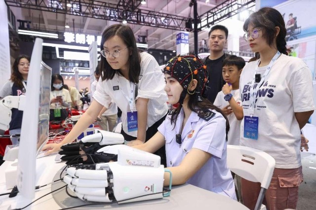 2023年8月21日、北京で行われた2023世界ロボット博覧会で、人工知能マルチモーダルBMIプラットフォームを体験する女性。撮影 陳暁根/人民図片